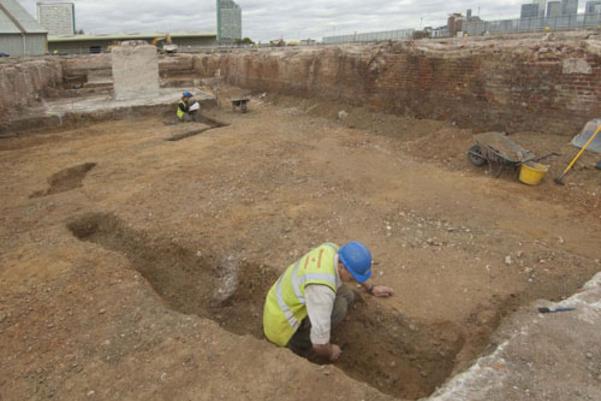 Archaeologist excavating a ditch
