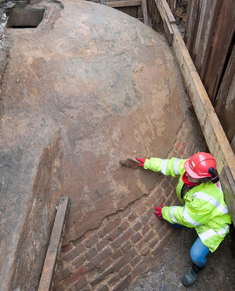 A MOLA archaeologist brushes the near-perfect exterior of the Regent's Crescent Ice House exposed during excavation in 2015