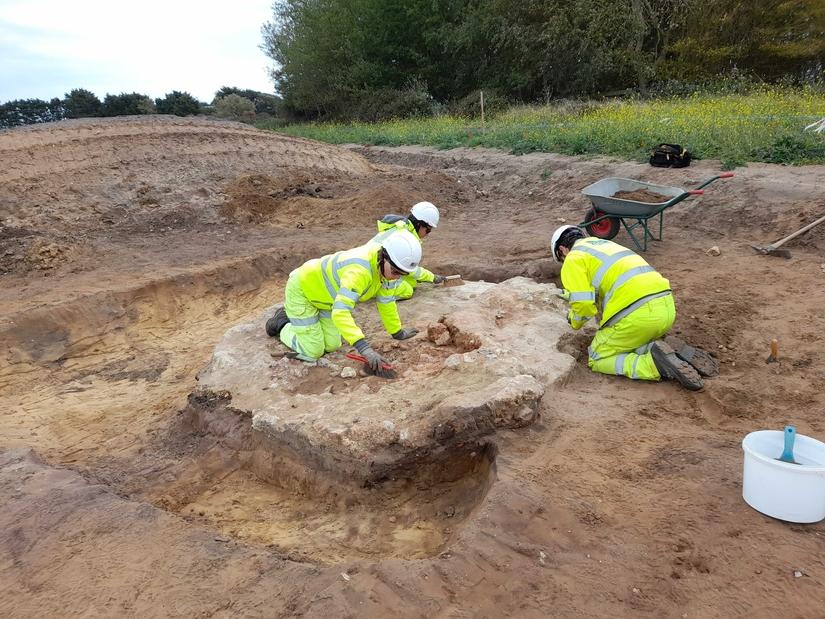 A group of archaeologists excavating the remains of a medieval kiln