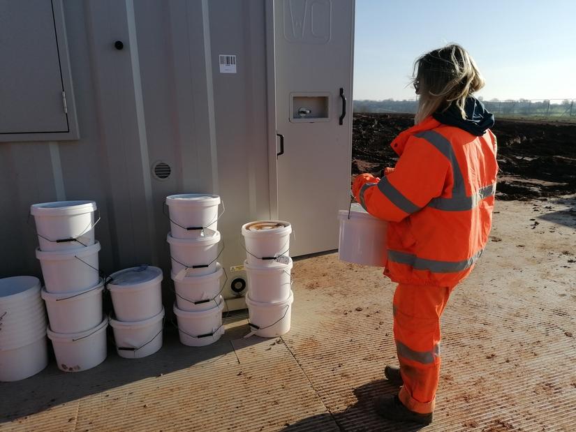 Archaeologist carrying a full sample bucket