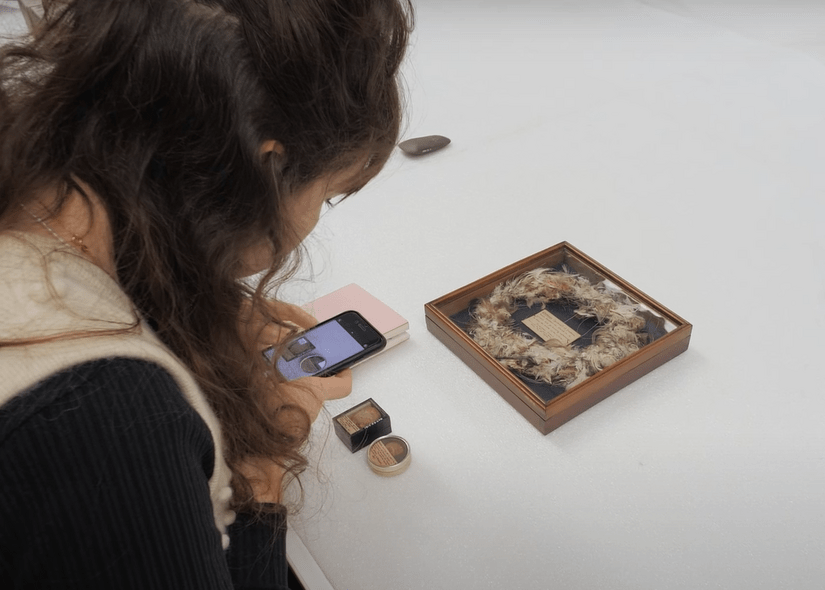 A person photographing objects in a museum display