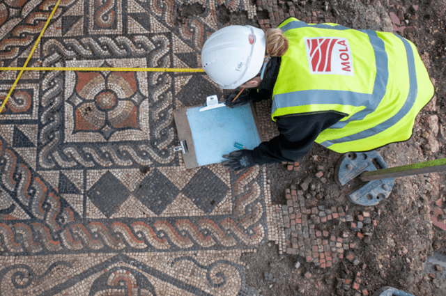 An overhead photograph of an archaeologist recording one of the Roman mosaics at The Liberty