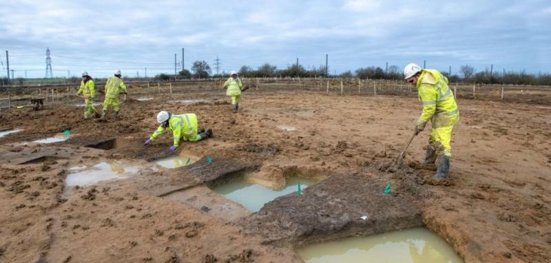 Photo of excavation showing square cuts out of circular roundhouse ditch