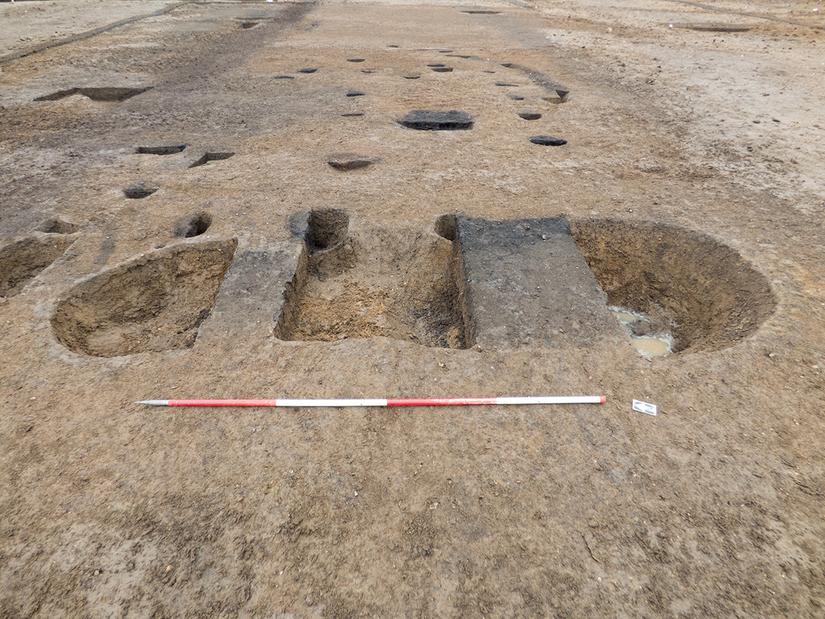 An over shaped excavation with dark soil in the middle
