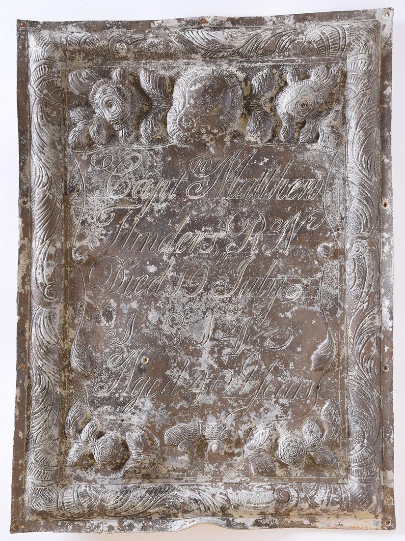 A rectangular shaped sheet of lead which is heavily decorated and inscribed