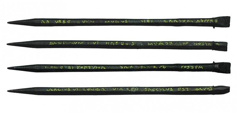 Composite image showing four sides of the stylus with carved text overwritten in yellow