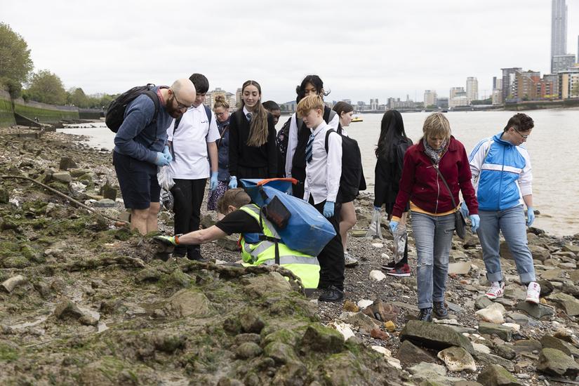 Photo of students watching an archaeologist explain what archaeology is present on the foreshore