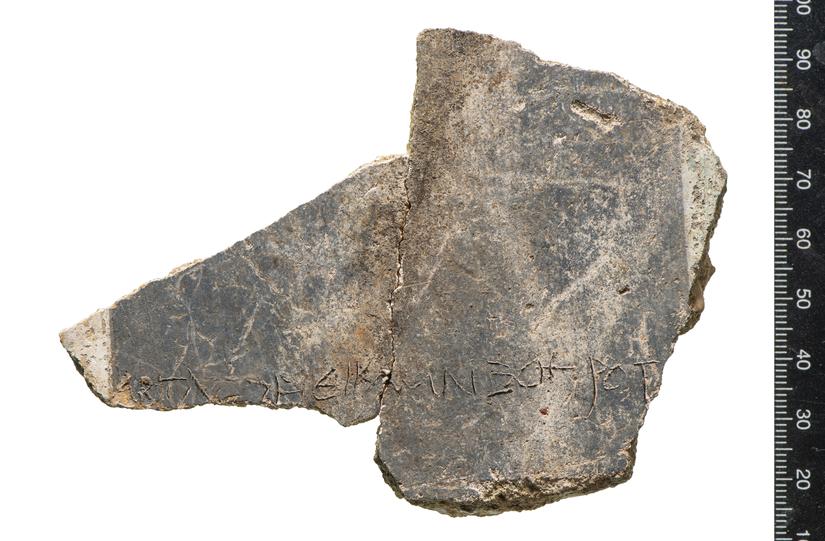 The fragment of plaster with an inscription of the ancient Greek alphabet