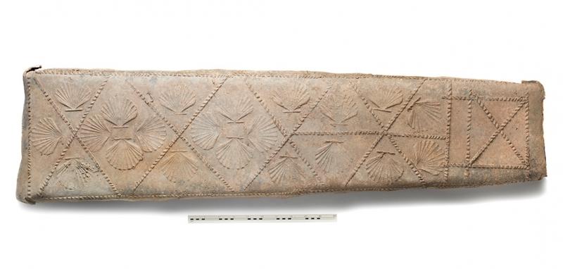 Photo of lead coffin with patterns that include shells and geometric lines