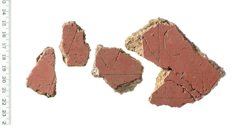 Four pieces of decorated plaster with the remains of letters on them, the only word which can be fully read is 'fecit'