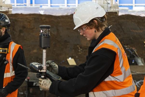 An archaeologist using equipment to record the site