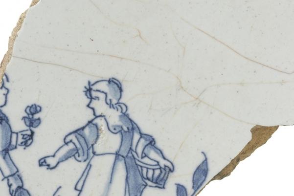 a blue and white tile decorated with the image of a girl and boy