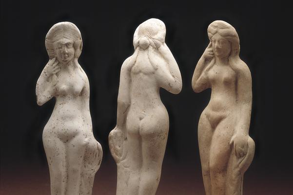 Three small statues of women