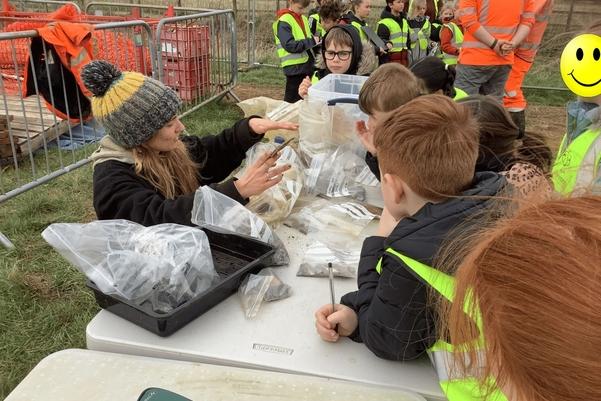 An archaeologist showing finds to a group of interested children