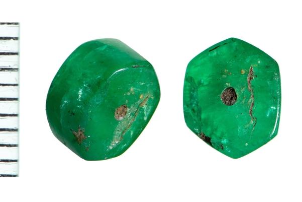 A picture showing the front and side view of a bright green bead. It is a six-sided shape with a tiny hole in the middle. A scale shows that it measures around 8mm in height.