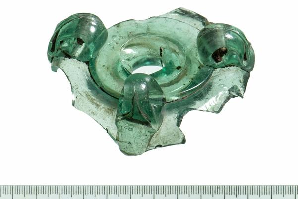 A green circular piece of glass with a hole in the centre