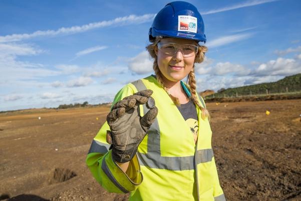 An archaeologist holding a worked stone tool