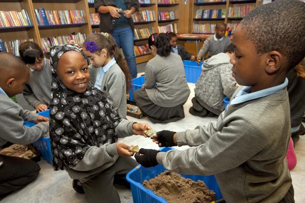 school children examine pieces of pottery