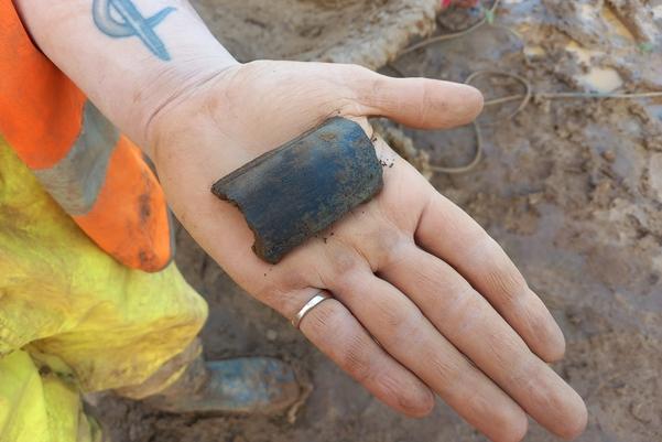 Hand holding a park piece of pottery