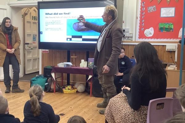 children sitting on the floor looking at a powerpoint presentation