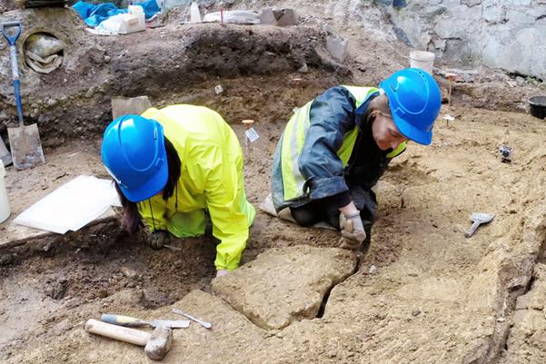 Conservators from MOLA removing a section of the 1st century upturned Roman wall plaster