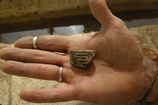Archaeologist holding a find from site