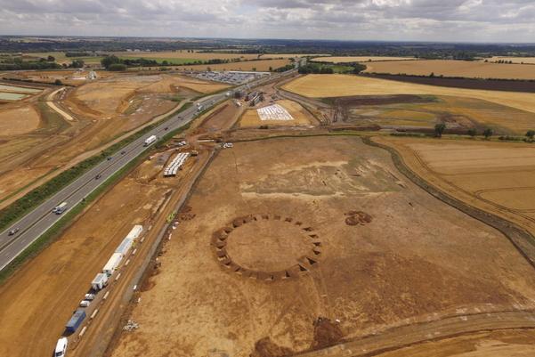 Aerial photograph of an excavation site. In the centre is the outline of a large circular monument