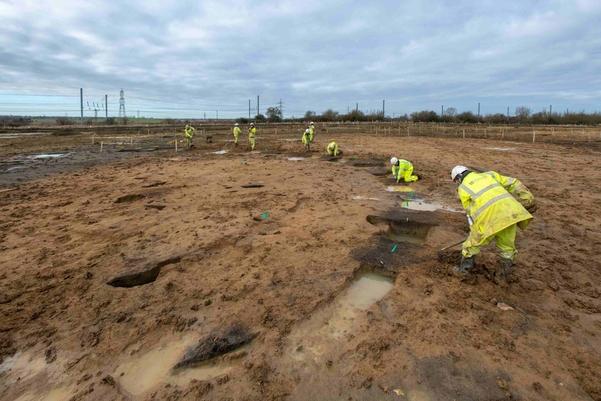 A group of achaeologists excavating a roundhouse