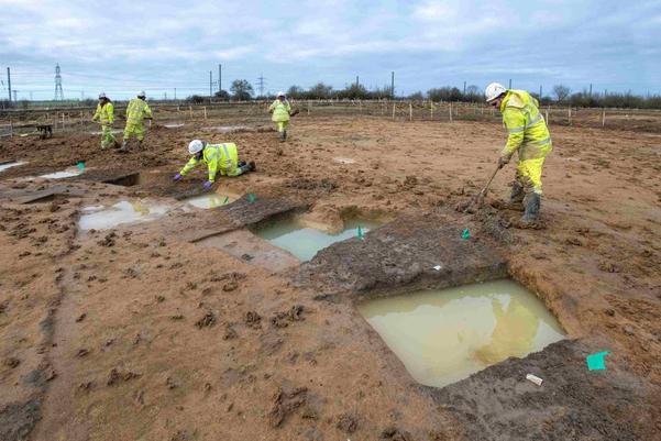 A group of achaeologists excavating a roundhouse