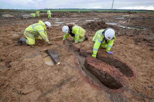 Three archaeologists excavating a Roman kiln