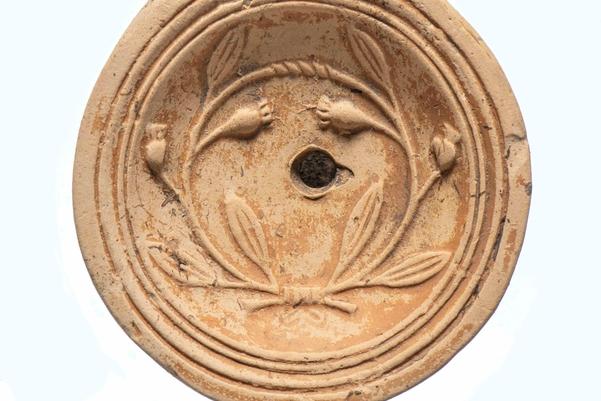 A clay oil lamp decorated with flowers