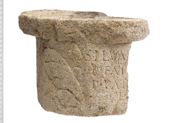 The base of a roman column with carved writing
