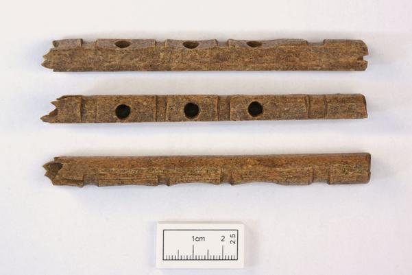 A composite image showing three different views of the reed pipe. Carved decoration and fingerholes can be seen