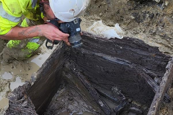 An archaeologist photographing the inside of the well