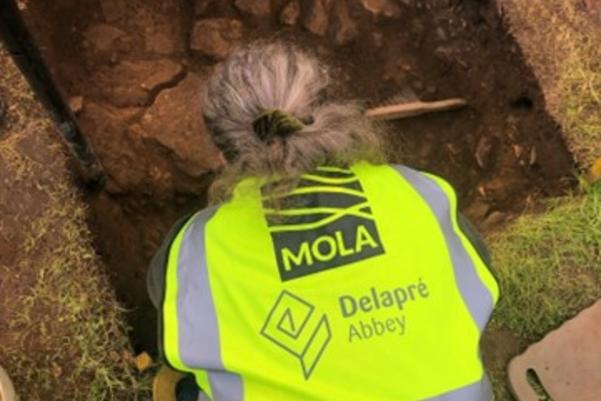 Volunteer digging in the test pit