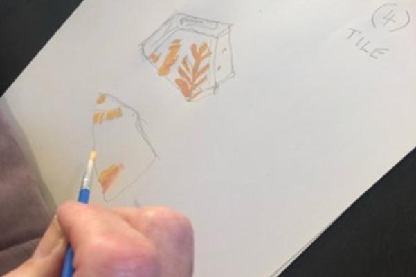 participant using watercolours to add detail to a drawing