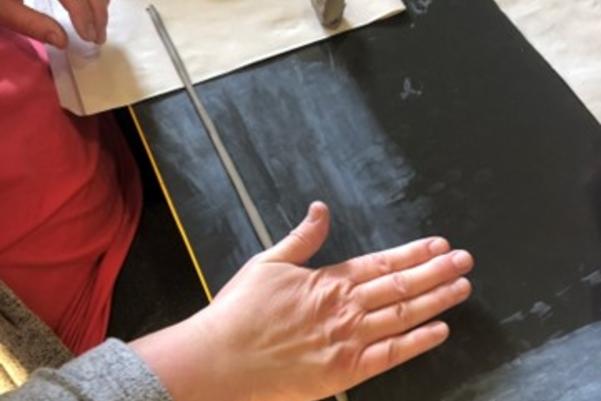 rolling out clay to make a cup