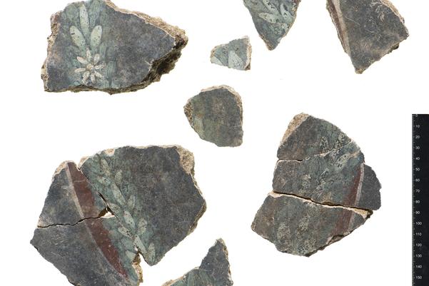 Sections of wall plaster decorated with a wreath or white flowers, today it is very fragmented