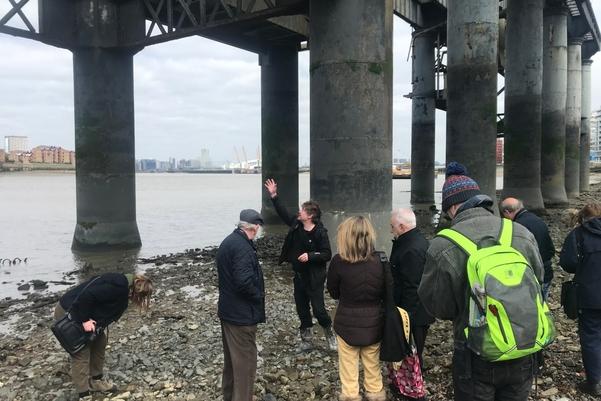 A group of people listening to a talk on the foreshore