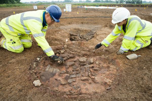 Two archaeologists excavating a Roman kiln