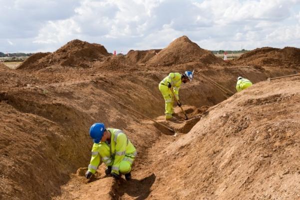 An archaeologist digging in a circular ditch