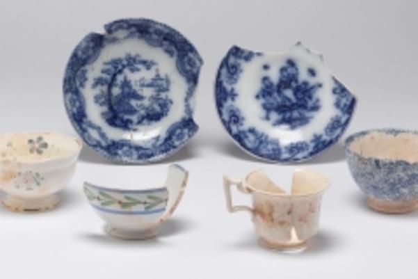 Photo of van Milingen china showing two chipped plates with blue on white design and four very chipped delicate cups