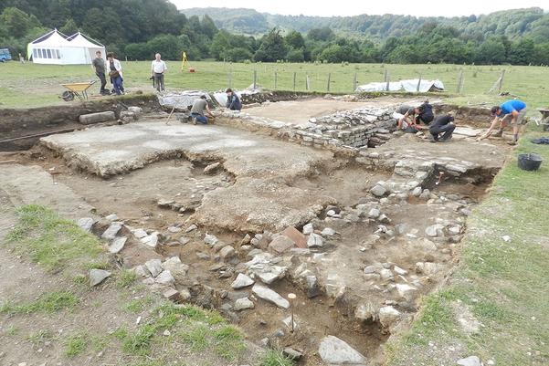 Archaeologists excavating the remains of stone buildings