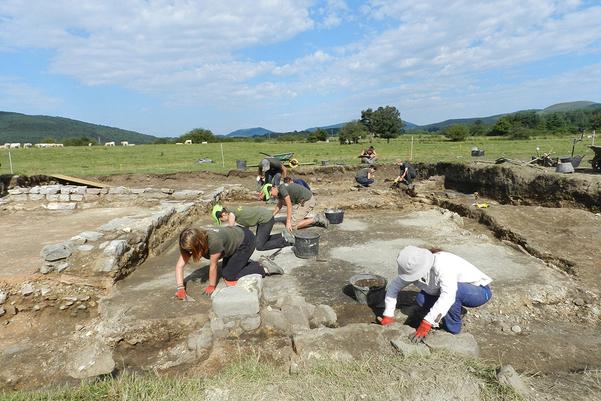 Archaeologists excavating the remains of stone buildings