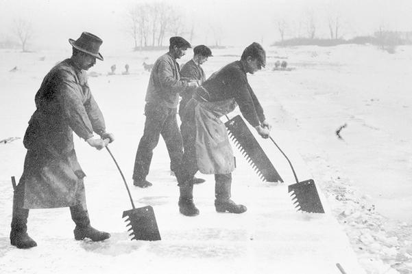 Workers saw blocks of ice from a frozen lake in Norway