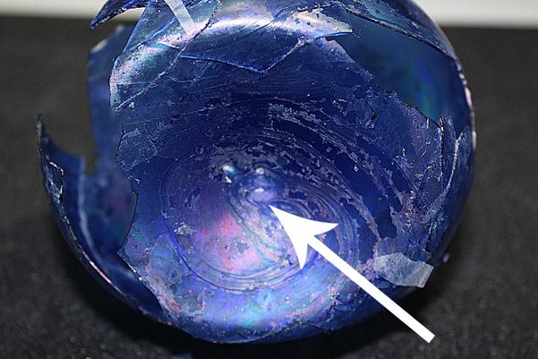 The bottom of the sprinkler with a mark on the bottom pointed to with an arrow